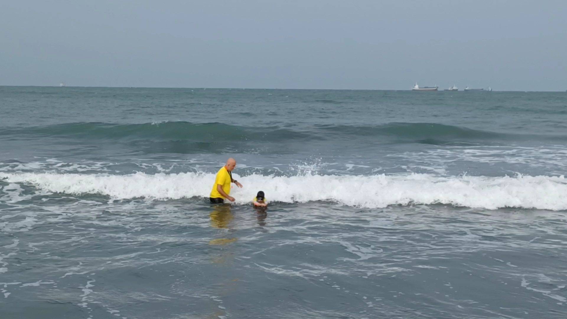 West Bay Nippers Lifesaving Taiwan Surf swim safety lesson. Coach and children bodysurfing and wading.
