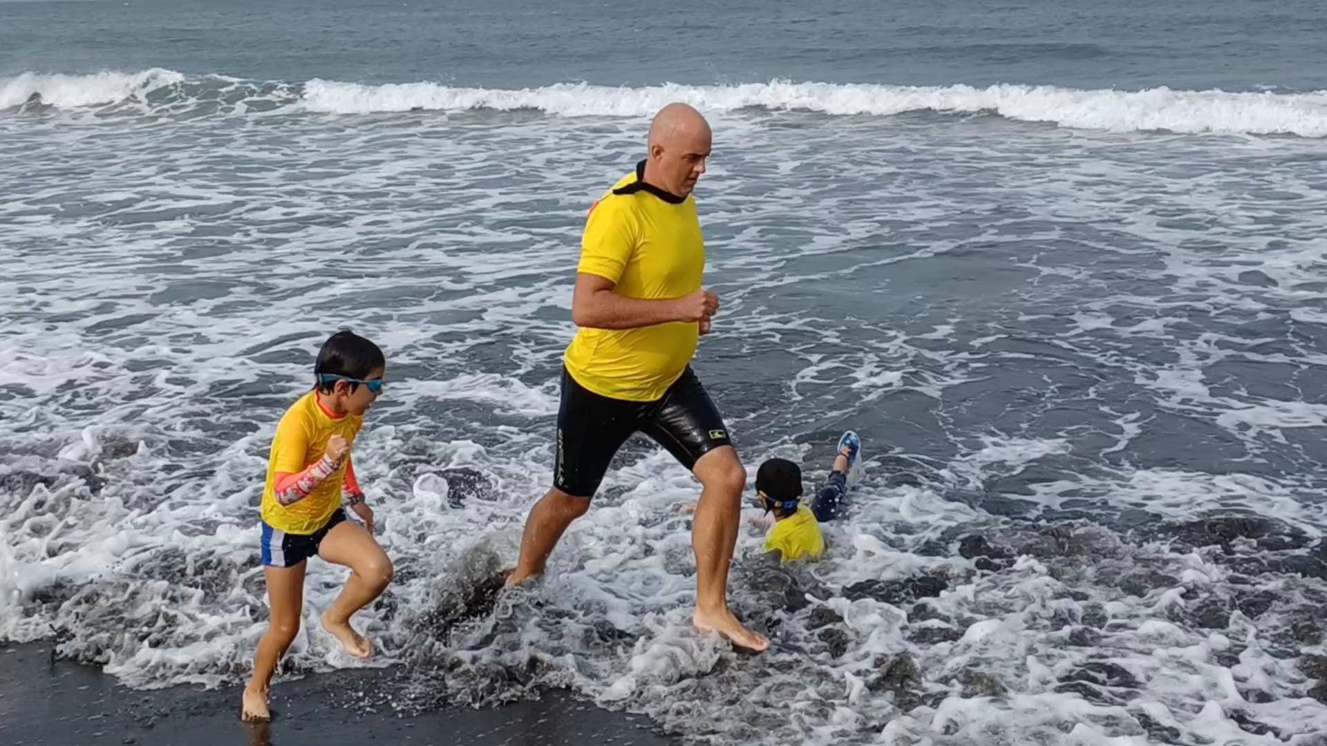 West Bay Nippers Lifesaving Taiwan Surf swim safety lesson. Coach and children bodysurfing and wading.